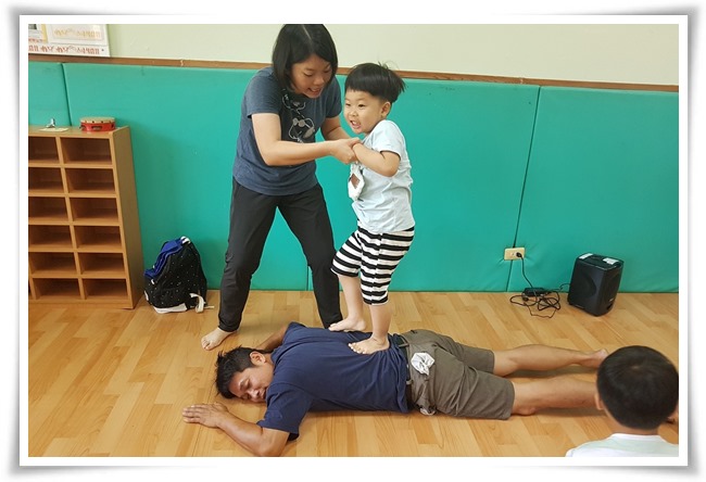老師引導孩子練習踩在家長的背上按摩提升親子互動