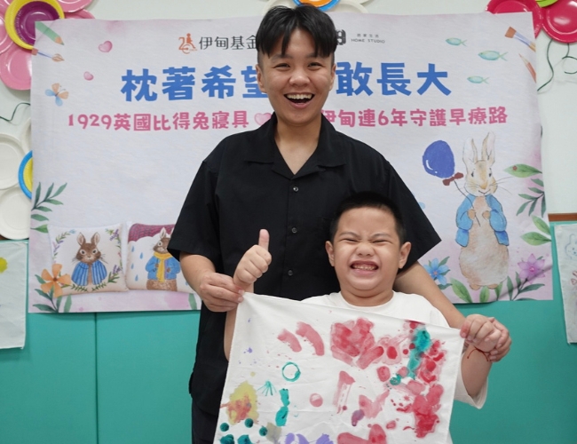 慢飛天使元元自信展示枕頭彩繪成果。