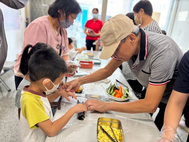 合和社區長輩細心引導孩子鋪設食材，體驗粄條壽司DIY。