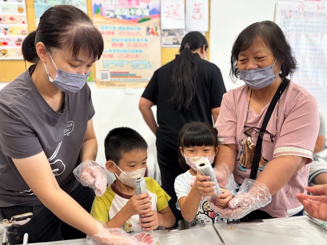阿嬤陪著孩子們開心展示完成的粄條壽司，現場充滿溫馨歡笑。