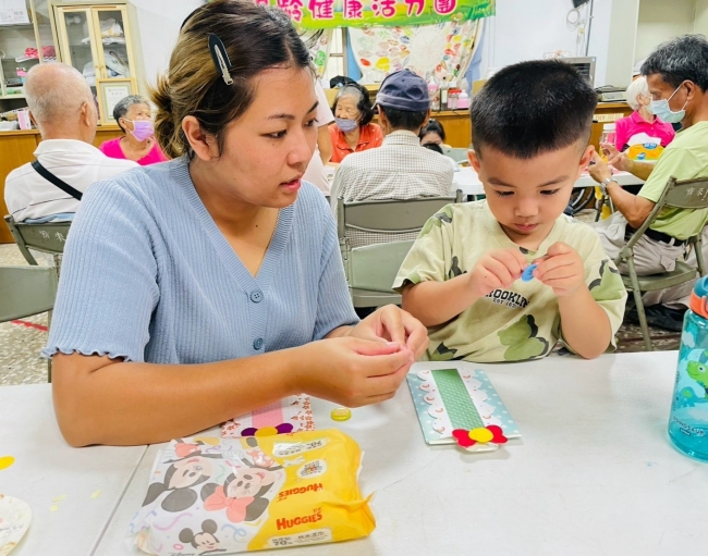 家長陪伴孩子專注進行父親節卡片裝飾與手作。