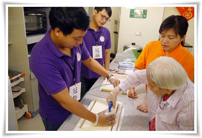 志工（冠勳）悉心教導老人家為綠豆糕脫模