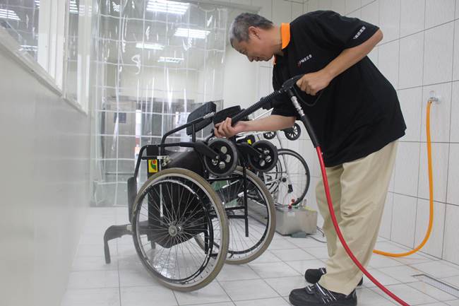 阿萬師輔具清潔工場透過高壓高溫及臭氧機進行輪椅清潔。