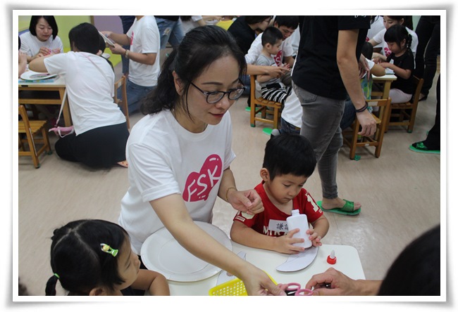 FSK新泰貿易有限公司總經理洪玉娟(左)帶領其下員工擔任志工陪伴慢飛天使製作玉兔帽