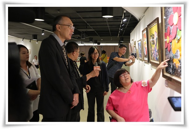 半癱的伊甸身障藝術家韾文與新北市副市長謝政達介紹拼布作品，展現十足的生命力