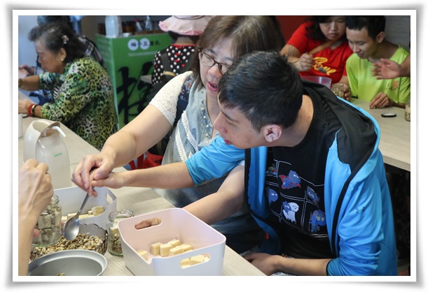 智能障礙的阿齊(右一)與媽媽體驗手作古早味豆腐乳的樂趣，溫馨畫面令人動容