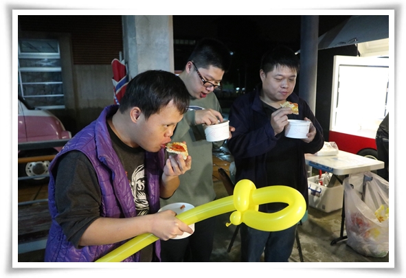 伊甸宜蘭教養院住民小逸與其他住民們在美食胖卡車旁開心地享受剛出爐的窯烤披薩。