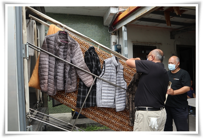 伊甸乾燥消毒車操作人員將阿公的衣服與寢具上架，進行除溼、消毒與烘乾等清潔工作。