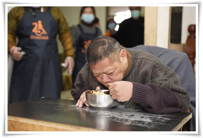 身障黃大哥開心享用熱騰騰的佳餚，有了伊甸的陪伴，讓他過年不再孤單。