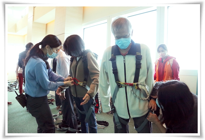 台北101不僅提供專業導覽服務，也有專人細心協助視障朋友們穿戴安全裝備。