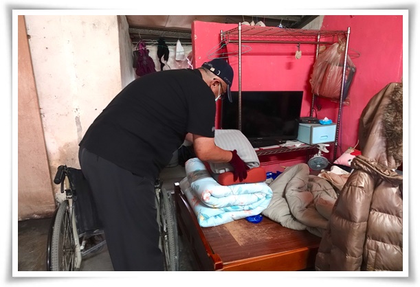 伊甸乾燥消毒車操作人員協助將完成消毒的寢具，依序折好進行收納。