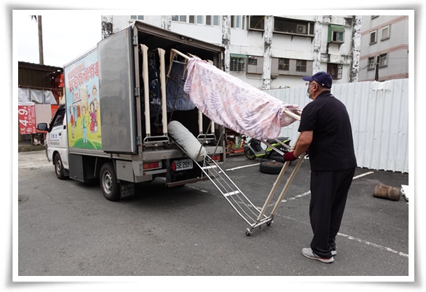 伊甸宜蘭乾燥消毒車操作人員將案家的被單與衣服上架，進行除濕、消毒與烘乾等清潔工作。