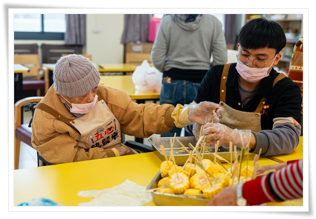 陳文魁阿公和照顧服務員分工合作，一起串食材