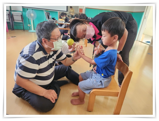 專業人員利用玩具提升慢飛天使的檢查配合度