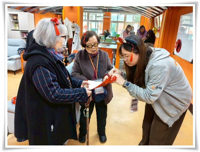 工作人員帶服務使用者貼春聯點綴會場，感受濃濃年節氛圍。