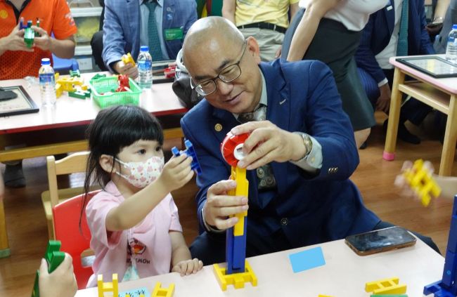 呂博進社長和慢飛天使合力完成花朵積木