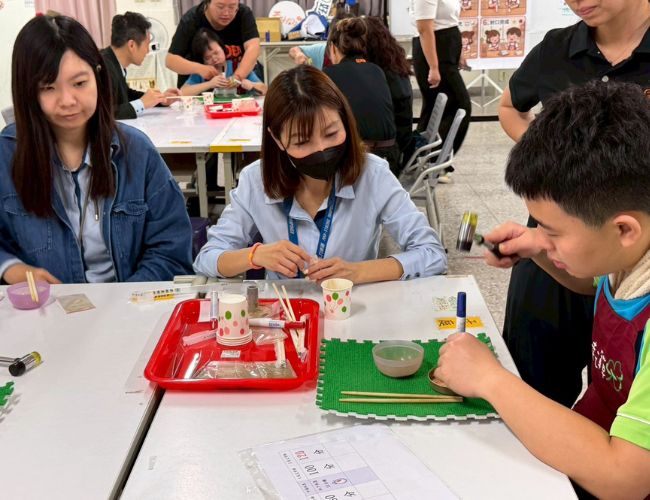 身障學員認真示範如何讓艾草絨壓實成條。